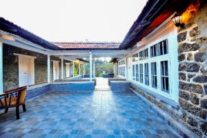 an empty courtyard of a house with a bench at Craigmore By Kodai Resort Hotel in Kodaikānāl
