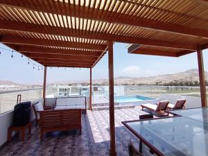 une terrasse avec une table, des chaises et une piscine dans l'établissement APARTAMENTOS CON PISCINA Y ACCESO A PLAYA, à Cerro Azul