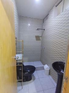 La salle de bains est pourvue de toilettes noires et d'un lavabo. dans l'établissement APARTAMENTOS CON PISCINA Y ACCESO A PLAYA, à Cerro Azul