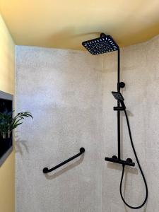 a shower in a bathroom with a black shower head at Sun Caraibes in Orient Bay