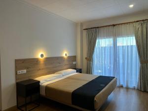 a bedroom with a large bed and a large window at La Luna Blanca in Torremolinos