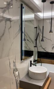 La salle de bains est pourvue d'un lavabo blanc et d'un miroir. dans l'établissement Amaliana by Florideiulie Apartaments, à Braşov