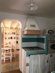 a kitchen with a stove top oven next to a dining room at Maison al Duomo in Messina +46 photos