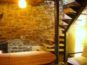 um quarto com uma parede de pedra com uma cama e escadas em Apartamento Rural La Aldea Perdida .VV 1434-AS em Pola de Laviana