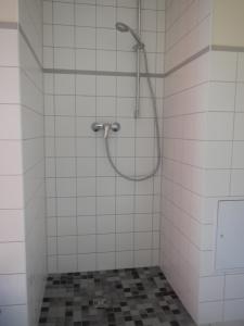 een douche in een badkamer met witte tegels bij Ferienlandhaus Zempow in Zempow