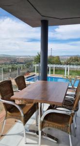 una mesa de madera y sillas en un patio con piscina en Casa en el corazón de Córdoba, en Montoro
