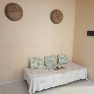 ein weißes Zimmer mit einem Bett mit drei Kissen in der Unterkunft Residencial Rosa Criola in Sal Rei