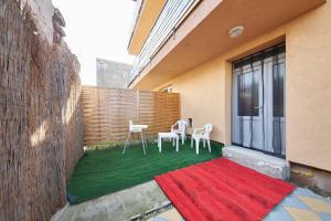 a patio with two chairs and a red rug at Relax apartment Bratislava in Bratislava