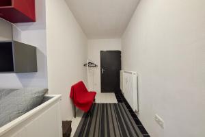 a room with a red chair and a black door at Relax apartment Bratislava in Bratislava