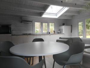 Cette chambre comprend une table et des chaises blanches. dans l'établissement Mezenhof, à Brasschaat