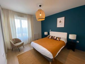 - une chambre avec un grand lit et un mur bleu dans l'établissement CAZAM Paris Saint Ouen, à Saint-Ouen
