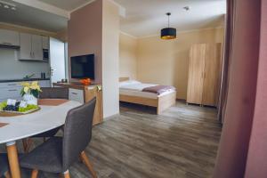 a hotel room with a bed and a table and chairs at Apartamenty ABRACADABRA in Ustroń