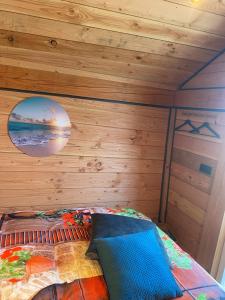 sypialnia z drewnianą ścianą i łóżkiem w obiekcie Hoogte Huisje Italien w mieście Swalmen