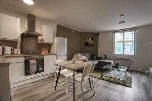 a kitchen and living room with a table and a couch at #26 Phoenix Court By DerBnB, Modern 1 Bedroom Apartment, Wi-Fi, Netflix & Within Walking Distance Of The City Centre in Sheffield