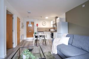 een woonkamer met een bank en een tafel bij #26 Phoenix Court By DerBnB, Modern 1 Bedroom Apartment, Wi-Fi, Netflix & Within Walking Distance Of The City Centre in Sheffield