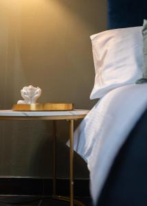 a side table with a bed and a white pillow at Windsor Court in Brighton & Hove