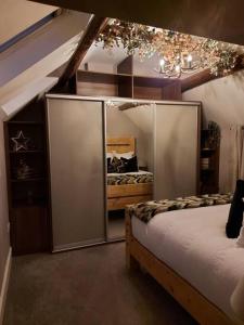 a bedroom with two beds and a chandelier at Woodys Retreat Cosy One Bed Cottage in Belper
