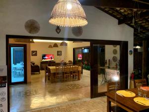 a dining room and living room with a dining table at Vila Sol Chalés in Pôrto de Pedras