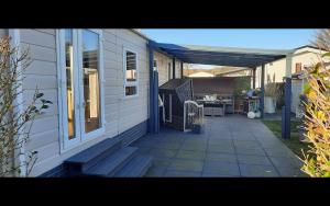 a porch of a house with a patio at Chalet Olive im Park De Veerstal in Lathum