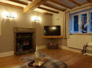 a living room with a fireplace and a tv at Woodys Retreat Cosy One Bed Cottage in Belper