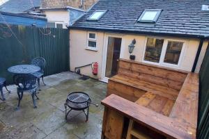 a patio with a wooden fence and a table and chairs at Woodys Retreat Cosy One Bed Cottage in Belper