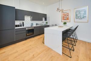 a kitchen with a white counter and black cabinets at Host & Stay - Princes Place Hideaway in Liverpool