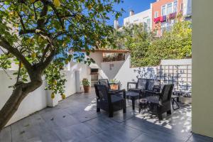 un patio con mesas, sillas y un árbol en Apartamento Moderno com Terraço en Lisboa