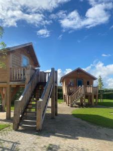 a couple of wooden cabins with stairs leading to them at Hoogte Huisje Italien in Swalmen