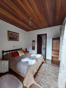 a bedroom with a large bed and a wooden ceiling at Pousada dos Marins in Campos do Jordão
