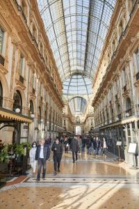 a group of people walking through a shopping mall at APPARTAMENTO Superhouse PIAZZA DUOMO AREA in Milan