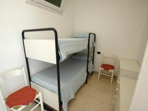 Zimmer mit 2 Etagenbetten und einem Stuhl in der Unterkunft Al Molo in Rio Marina