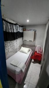 um pequeno quarto com uma cama e uma janela em Casa em Gamboa em Gamboa