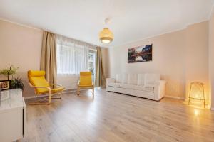 uma sala de estar com um sofá branco e duas cadeiras em Charmante Wohnung em Hanôver