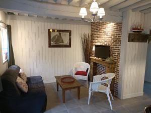 a living room with a couch and chairs and a tv at Lovely cottage in Honfleur center in Honfleur