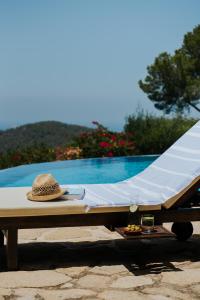 un cappello di paglia seduto su un tavolo accanto alla piscina di Paissa d'en Bernat a Cala Tarida