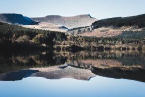 un reflejo de una montaña en un cuerpo de agua en James' Place at The Taff en Merthyr Tydfil