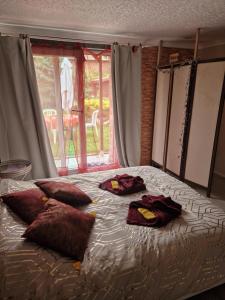 ein Bett mit Kissen darauf in einem Zimmer mit Fenster in der Unterkunft Chez mumu 