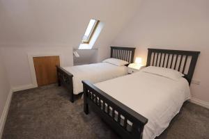 1 Schlafzimmer mit 2 Betten und einem Fenster an der Wand in der Unterkunft Royal Hillsborough Village Luxury Townhouse in Hillsborough