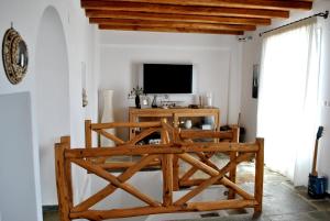 a living room with a tv and a wooden table at Pénde Traditional Villas in Serifos Chora