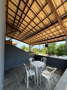 eine Terrasse mit einem Tisch und Stühlen unter einer hölzernen Pergola in der Unterkunft Casa Praia de Tabatinga 2 a 70m do Mar in Conde