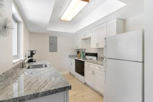 een keuken met witte kasten en een witte koelkast bij Unit 4 Spacious 1 bedroom Apartment with 70inch smart TV in Fort Lauderdale