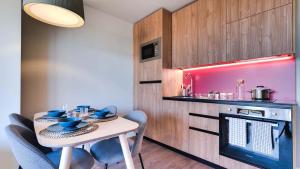 cocina pequeña con mesa, sillas y fogones en Livensa Living Studios Madrid Alcobendas, en Alcobendas