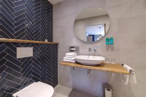 a bathroom with a sink and a mirror at Hotel De Zilte Zeeuw in Kortgene