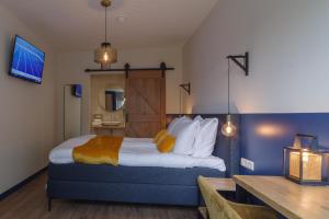 コルトゲーネにあるHotel De Zilte Zeeuwのベッドとデスクが備わるホテルルームです。