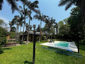 a yard with a swimming pool and palm trees at La Quinta in Corrientes