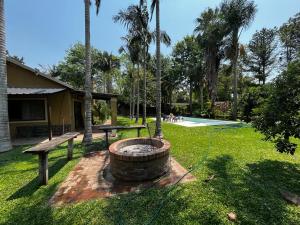 a garden with a fire pit and a bench and palm trees at La Arboleda in Corrientes