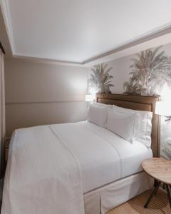 a bedroom with a large white bed and a table at AlmaLusa Alfama in Lisbon