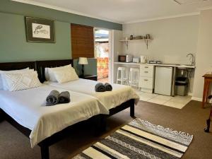 1 dormitorio con 2 camas y toallas. en Lovely Garden Studio1 - 10 minute walk from beach, en Ciudad del Cabo