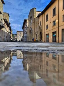 una calle vacía con un reflejo de una iglesia en Borgo di Piero, en Sansepolcro