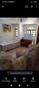 ein Zimmer mit zwei Betten und einem Schreibtisch in der Unterkunft Casa para temporada em São Pedro da Aldeia Até 6 pessoas in São Pedro da Aldeia